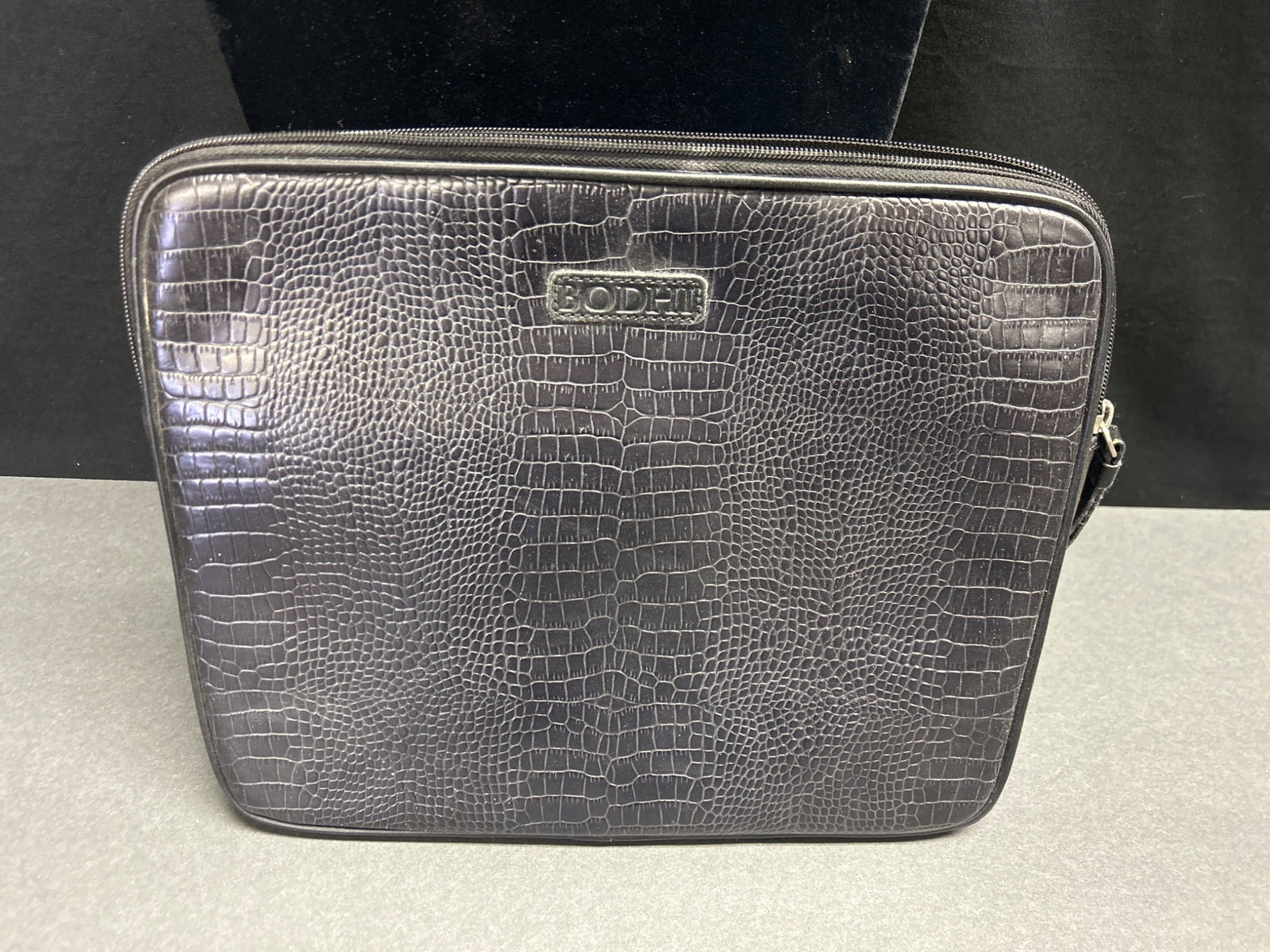 Bodhi Leather Textured Pouch with Zipper Closure: A leather textured pouch by Bodhi featuring an embossed crocodile pattern with a zipper closure. Includes the Bodhi logo on both the exterior and interior tags. Designed in New York and handcrafted