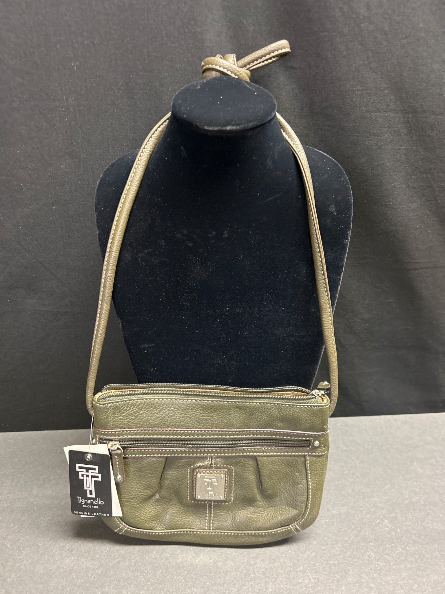 Tignanello Genuine Leather Crossbody Bag, Olive Green with Tags: This is a Tignanello crossbody bag made of genuine leather in olive green. It features multiple zippered compartments, including exterior and interior pockets, and a fully lined interior with a satin