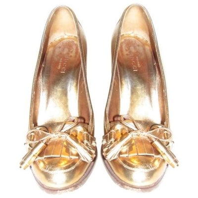 Gucci 'Marrakech' Gold Metallic Leather Equestrian: For sale is a pair of GUCCI, 'Marrakech', size 5.5B, gold metallic leather, 4" heeled loafer with tassels and equestrian accents at the toes! These heeled loafers by Gucci create a perfect retro look