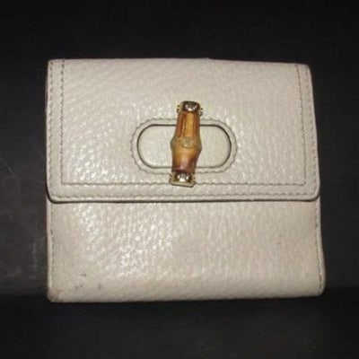 Vintage Gucci Ivory Pebbled Bi-fold Bamboo Accent: Vintage Gucci ivory pebbled leather bi-fold wallet with a leather strap snap closure on one side, a bamboo accent twist closure change purse on the other side, and lots of slots for your cards! This i