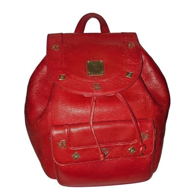 MCM vintage red leather backpack with gold hardware: For sale is a vintage MCM red leather backpack with gold-tone hardware, dual shoulder straps, a front exterior snap & side zip pocket, logo print canvas lining, and adrawstring closure at the top.