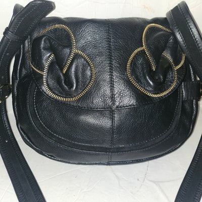 See By Chloe black pebbled leather saddle bag with two leather flowers: For sale is an early See By Chloe black pebbled leather saddle bag with two leather flowers with gold zipper accents & lots of room. This is a chic & edgy Chloe saddle bag that would look grea