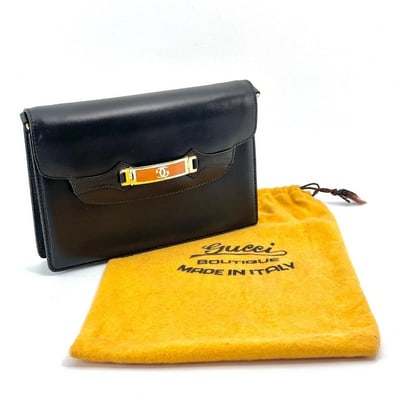 Gucci black leather two-way mini purse with a yellow enamel clasp: This exquisite Gucci mini purse is a timeless statement piece that seamlessly blends luxury and versatility. Crafted from supple black leather, the compact silhouette offers the perfect balance of ele