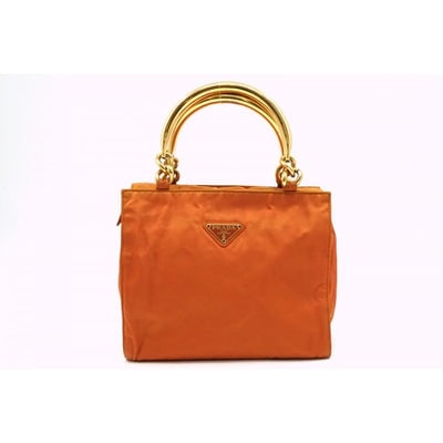 Prada orange re-edition 2000 satchel with gold metal handles: For sale is a Prada orange nylon re-edition, boxy satchel with two, hard gold metal handles engraved 'Prada', Prada store card, black Prada logo lining, multiple pockets, and an iconic Prada style. Di