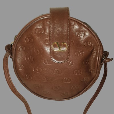 Valentino brown leather round canteen style bag w logo embossed: Discover timeless elegance with this authentic Valentino brown leather canteen bag, a sophisticated accessory that seamlessly transitions from day to evening. Crafted from supple leather in a rich tof