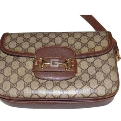 Early Gucci 1955 Horsebit tan Guccissima print bag: It is a large, envelope top, shoulder bag made of brown Guccissima print coated canvas & leather with a large gold equestrian accent at the center where it closes & sides where the strap is at
