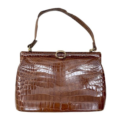 Gucci brown crocodile leather top handle purse: Step into timeless luxury with this exquisite 1960s Gucci brown crocodile leather top handle purseâ€”a masterpiece of vintage Italian craftsmanship. The rich, warm brown crocodile leather