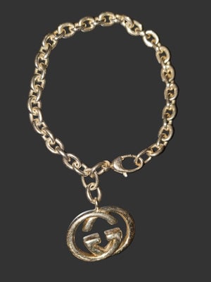 Gucci sterling silver iconic oval link charm bracelet w large interlocking G charm!: For sale is a discontinued, Gucci, sterling silver, AMAZING, substantial, charm style bracelet with a large, 1" x 1.5", 'GG' logo charm! The bracelet is gorgeous, iconic, and unique! It is a cla
