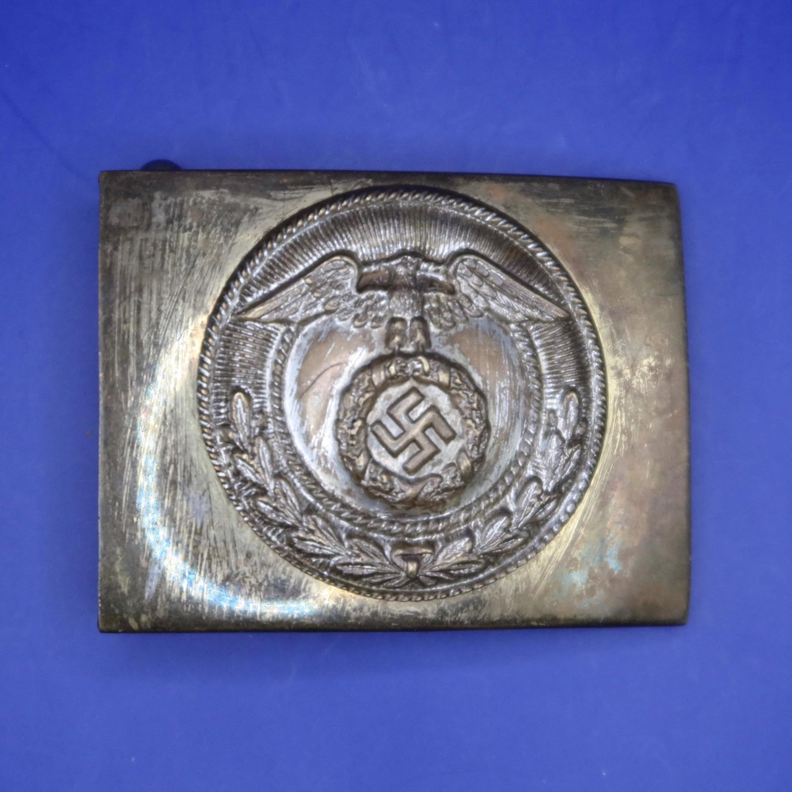German NSDAP SA EM/NCO belt buckle: Original German NSDAP SA EM/NCO belt buckle of two-piece, stamped brass construction, measuring approximately 65 × 50 mm with a slightly convex profile. The obverse features a plain field with an emb