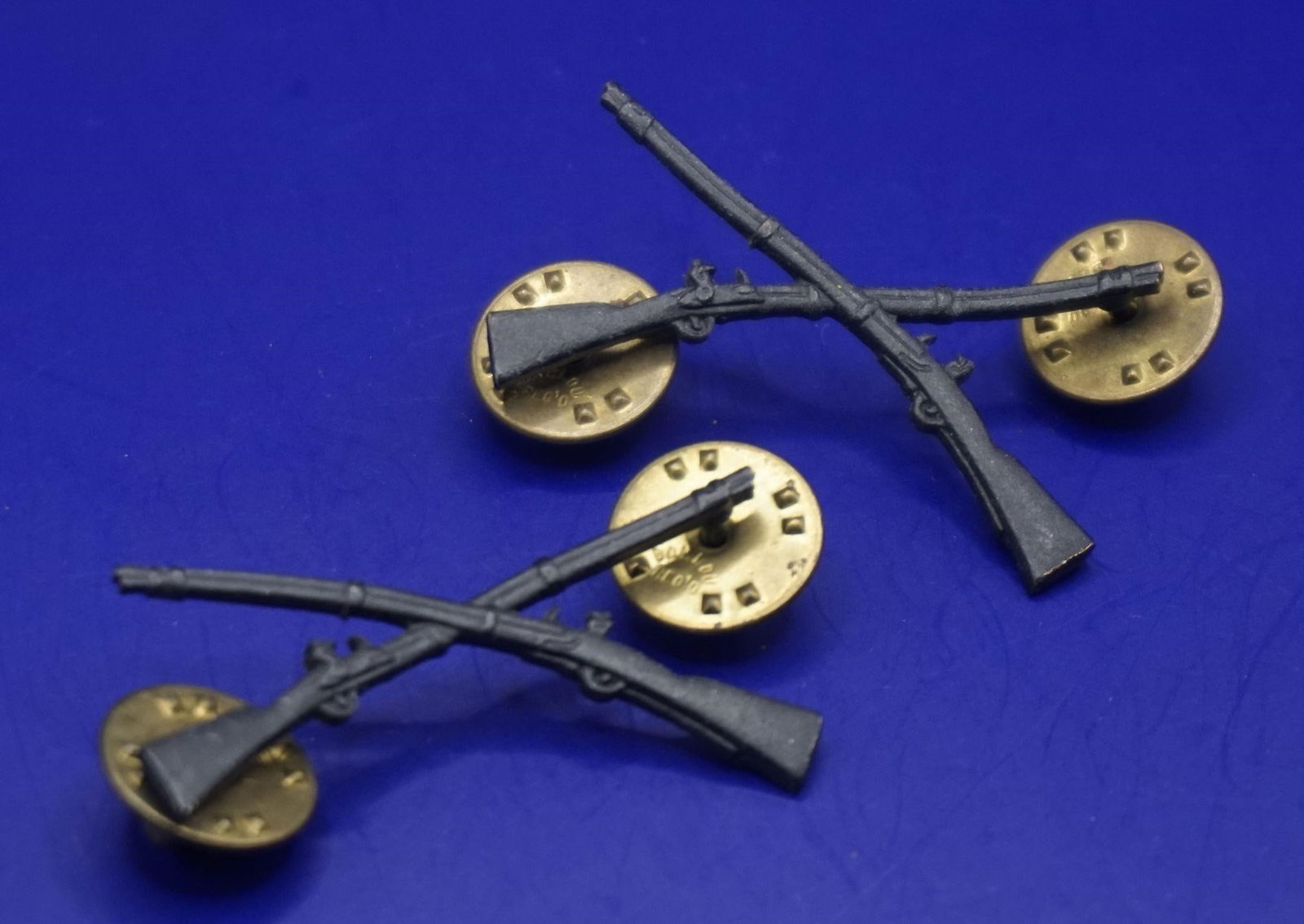 WWII US Army Infantry Officer Branch Insignia Set: This is a set of US Army infantry officer branch insignia, featuring crossed muskets on brass backing. The design, consisting of crossed rifles or muskets, was first introduced as the insignia for Inf