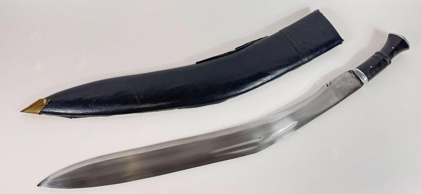 Vintage Gurkha Curved Combat Knife w/ Sheath: This a Gurkha kukri knife with a leather sheath. The user query uses terminology found in online listings, suggesting the item is a vintage or modern reproduction from India rather than an antique mil