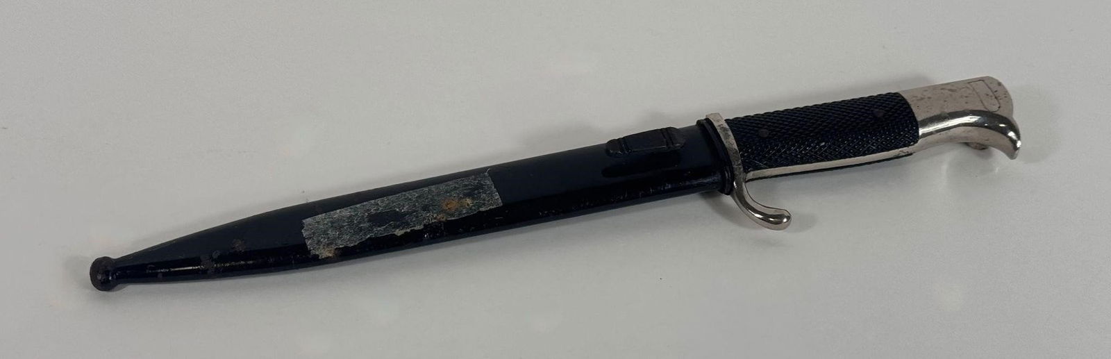 WWII German KA98 Dress Bayonet & Scabbard N/M: It features a nickel-plated blade and fittings. The grip plates are black checkered Bakelite or a similar material. The overall length of these bayonets varied, with typical blade lengths around 8 to