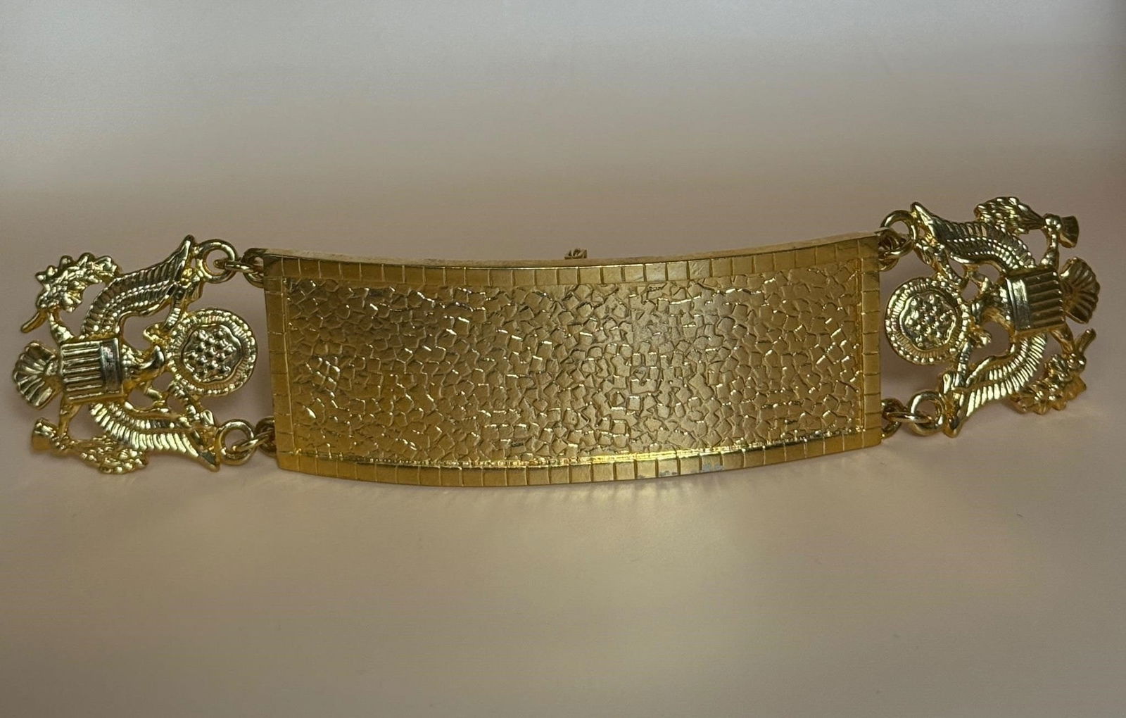 Metal Cuff, US Military decorative links..: Gold-tone metal cuff or bangle bracelet featuring an identification plate with a hammered or textured finish and eagle-shaped decorative links. Dimensions: 6.5in x 1.5in x 1/8