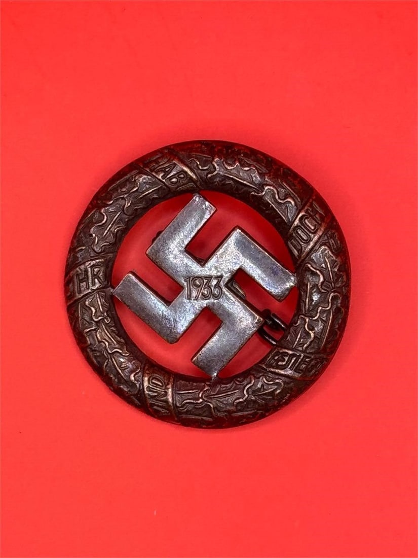 1933 Gau München badge - Deschler & Sohn, München: Dimensions: 1.5in1933 Gau München badge - Deschler & Sohn, München. Early pre war tombac 1933 Gau badge with Deschler makers mark and soldered on setup. Bronze copper color finish. Remains in good l