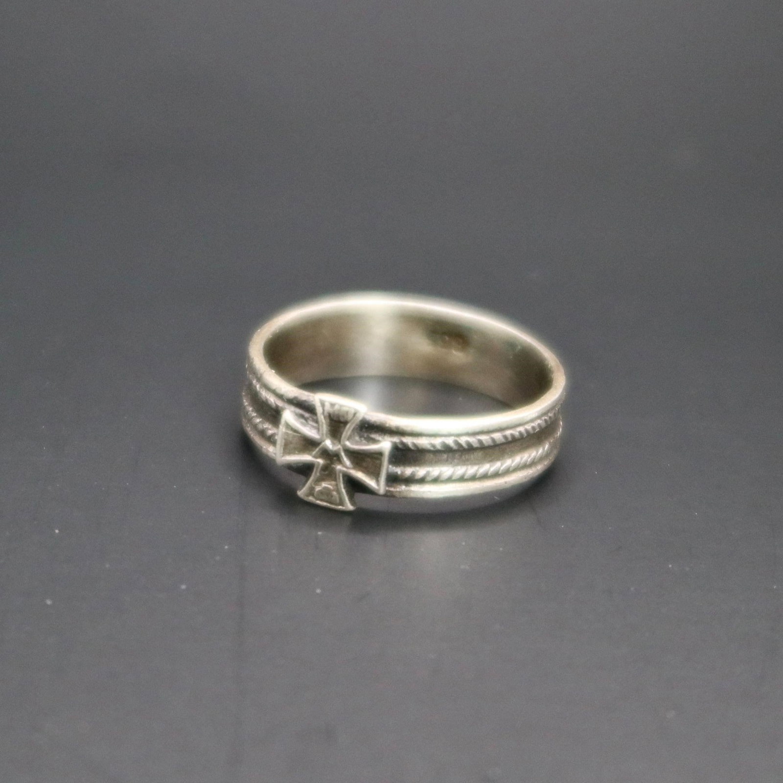 WWII German Silver Patriotic Iron Cross Ring: A silver patriotic ring from the World War II era, decorated with a raised Iron Cross at the center. The band features two rope-style relief lines running around it, and the inside is stamped with a s