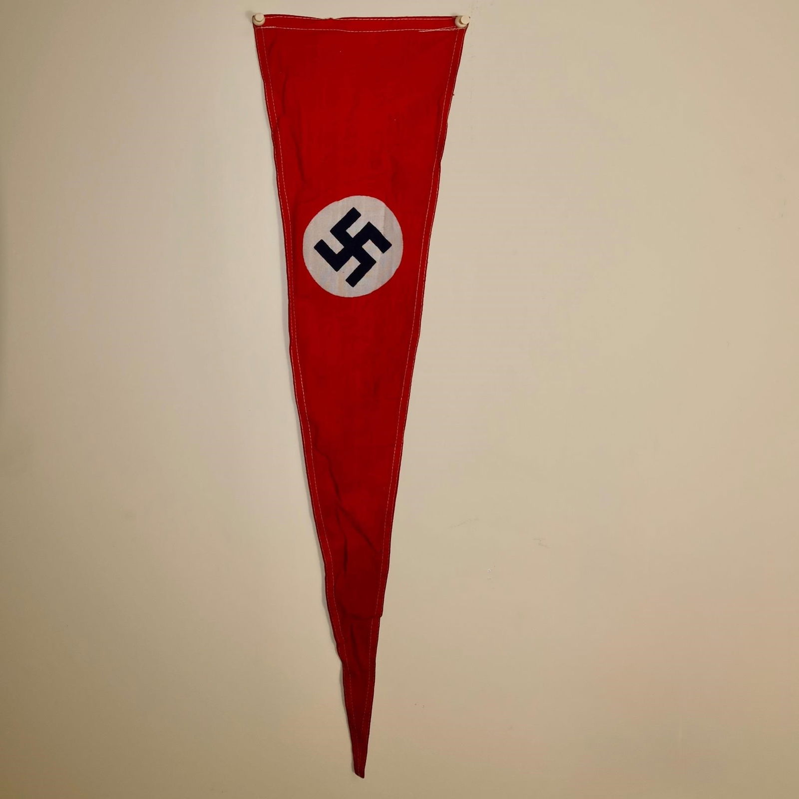 WWll German Red Flag: Red cloth flag with a white circular roundel at the center, bearing a black angled swastika. Measures approximately 27 × 7 inches.
