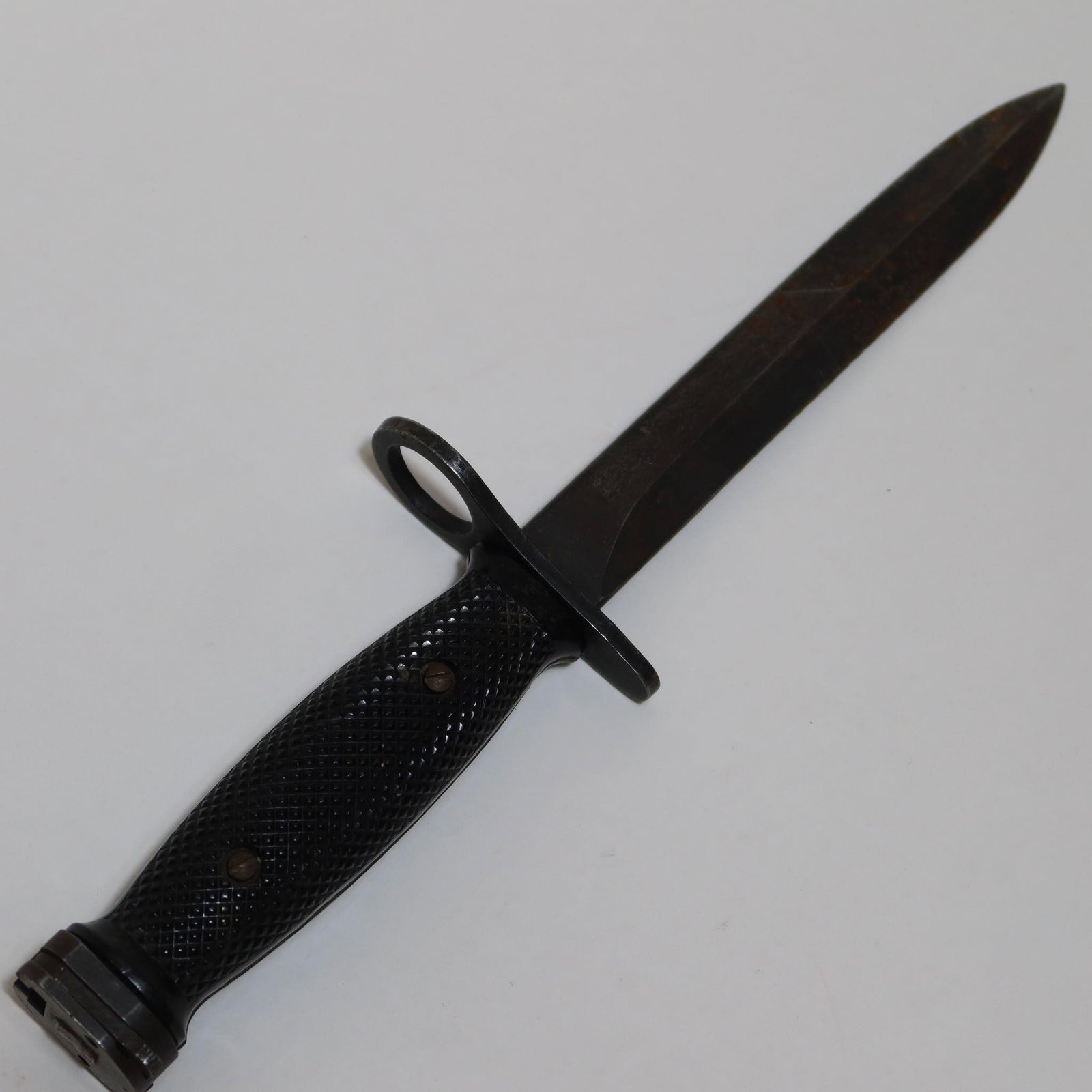 Vintage Vietnam Era U.S M7 Bayonet: Vintage Vietnam Era U.S M7 bayonet featuring a steel spear-point blade and a black textured grip with metal hardware. Includes a muzzle ring and solid steel guard, typical of classic military bayonet