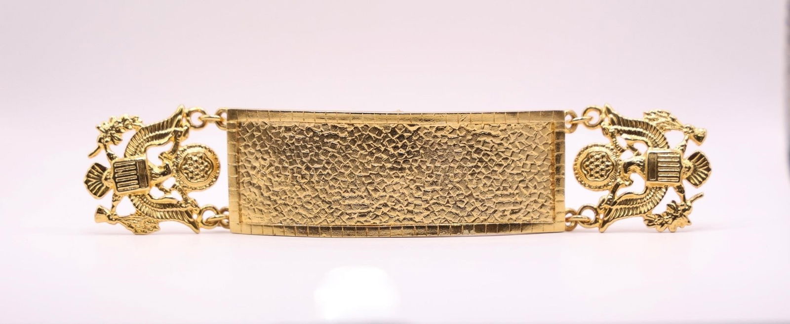 Metal Cuff, US Military decorative links..: Gold-tone metal cuff or bangle bracelet featuring an identification plate with a hammered or textured finish and eagle-shaped decorative links.Dimensions: 6.5in x 1.5in x 1/8