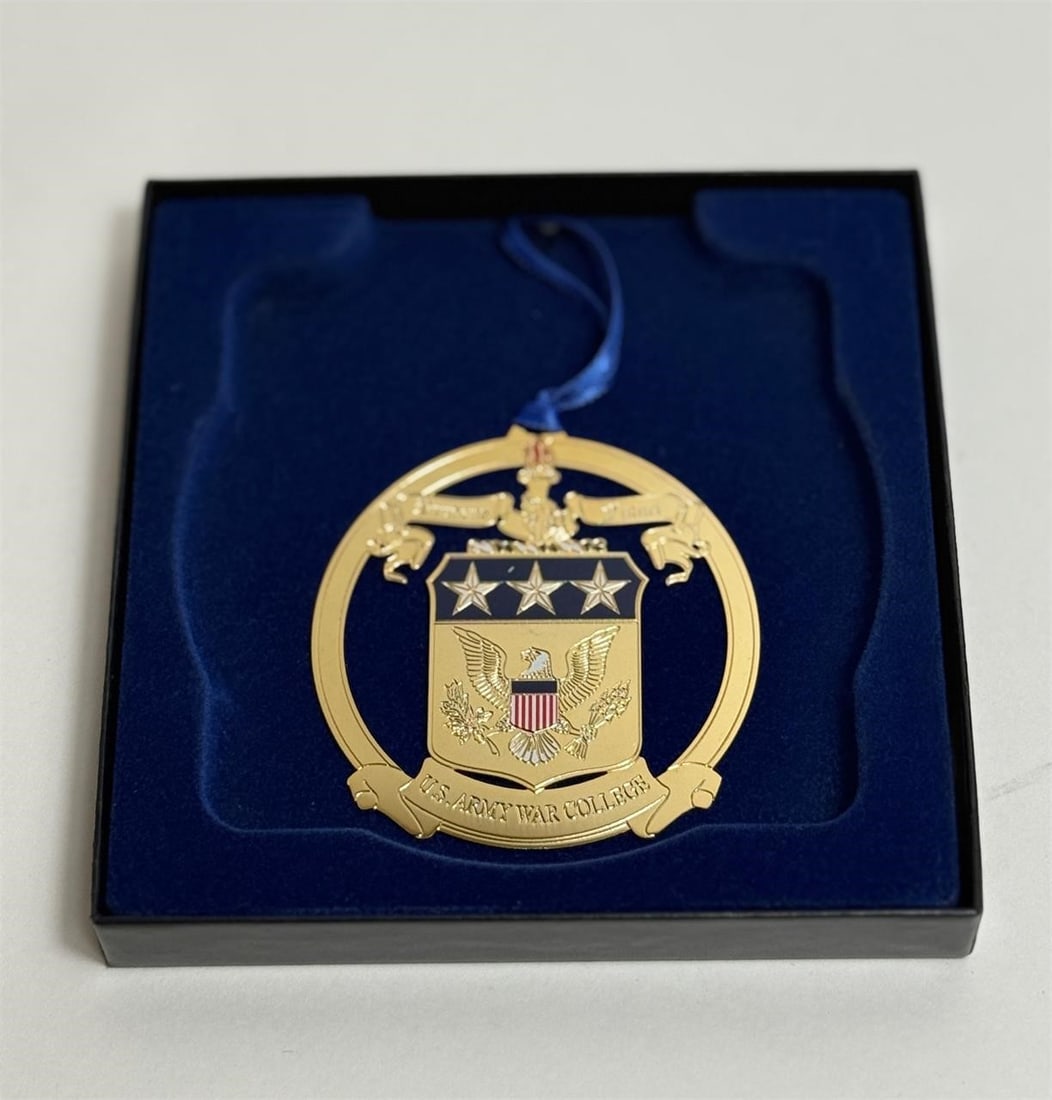 U.S. Army War College Ornament: Gold-tone metal ornament, likely made of brass or a similar plated alloy, often created as an annual collectible or fundraiser keepsake.Dimensions: 5 1/4in x 5 1/4in x 1in