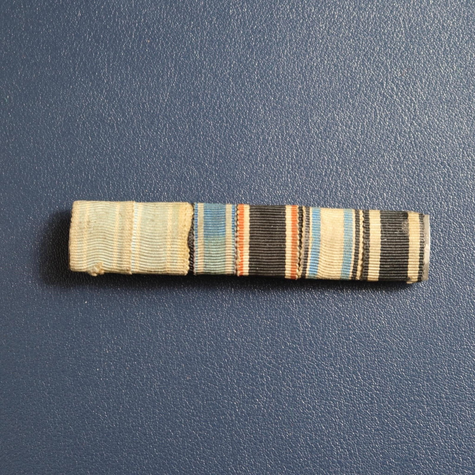German Medal Ribbon Bar Grouping: Collection of seven historic German medal ribbons, featuring awards from both World War I and World War II. Includes a variety of service, campaign, and merit decorations. Metal core with horizontal