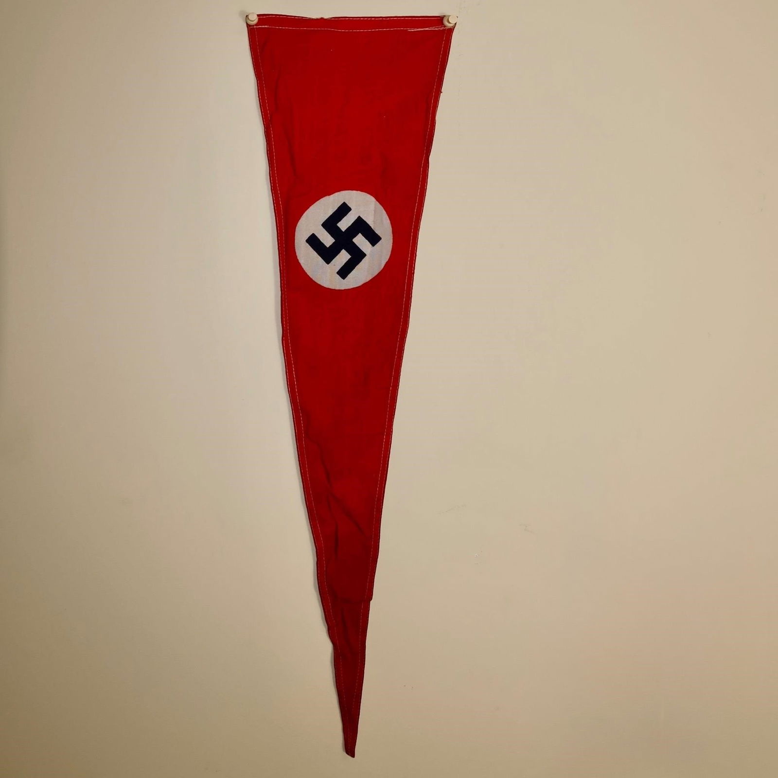 WWll German Red Flag: Red cloth flag with a white circular roundel at the center, bearing a black angled swastika. Measures approximately 27 × 7 inches.