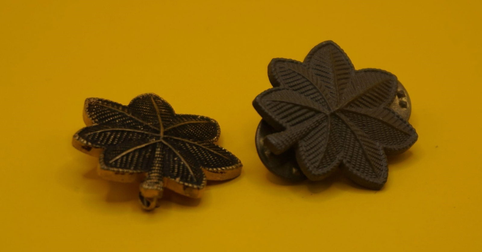 WWII Vintage US Army Major Rank Insignia Pins: This is a pair of US Army Major rank insignia pins. The insignia is a gold and subdued brown oak leaf. A gold oak leaf (left pin) signifies the rank of Major (pay grade O-4). A silver oak leaf (not