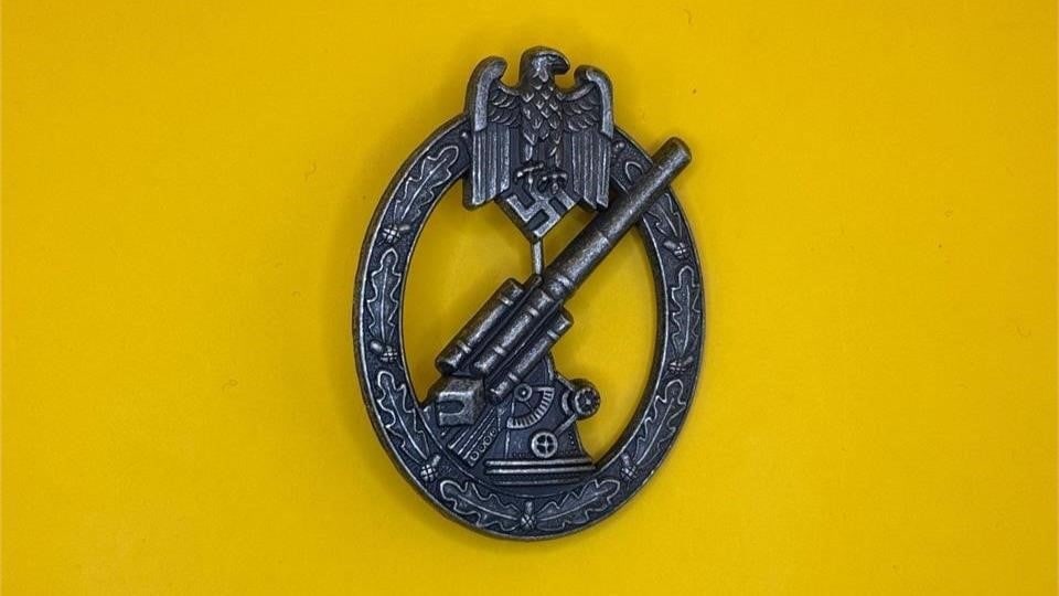WWII German Heer Flak Badge: Instituted on 10 January 1941 by Hermann Göring, the Heer Flak Badge recognized German Army anti-aircraft units for group combat achievements. Designed by Wilhelm Ernst Peekhaus, the badge features