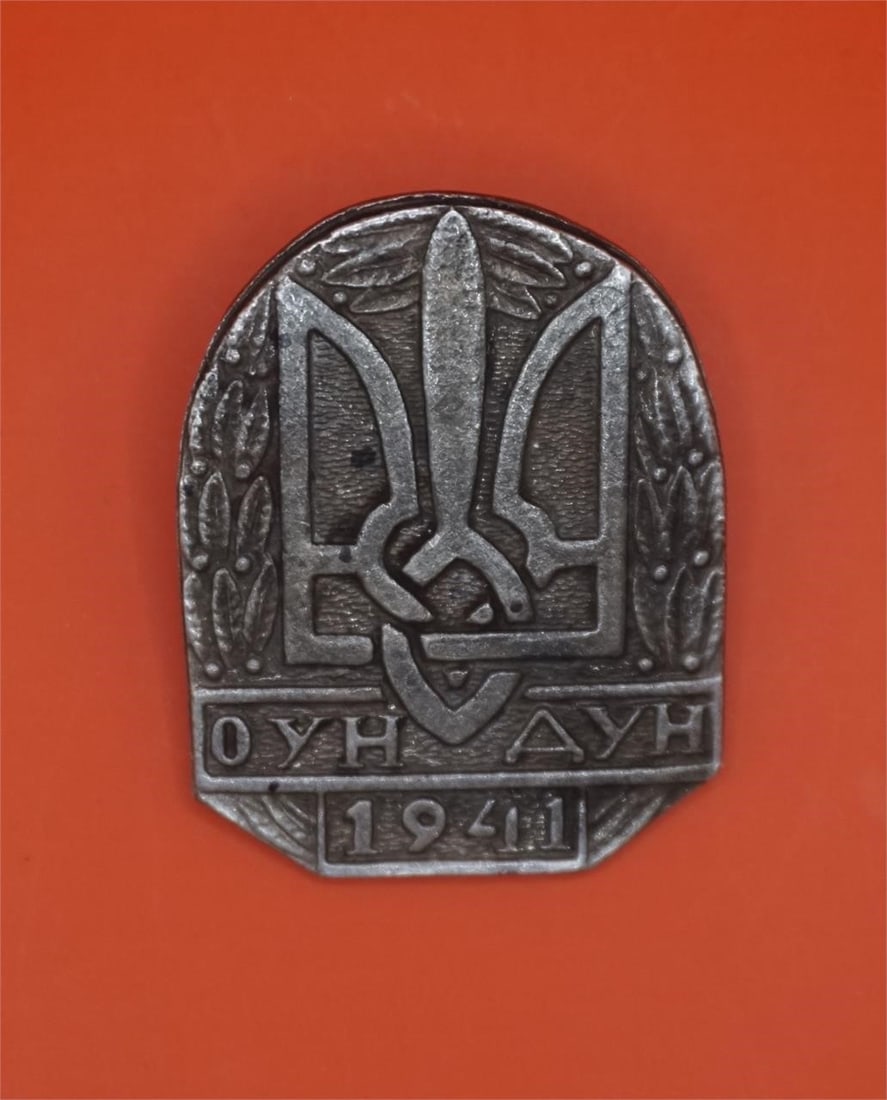WWII Ukrainian OUN and DUN Organization Patch: This is a badge of the Organization of Ukrainian Nationalists (OUN) and the Ukrainian Nationalist Squadron (DUN) from 1941. The badge features the Ukrainian coat of arms, the Tryzub (trident).The