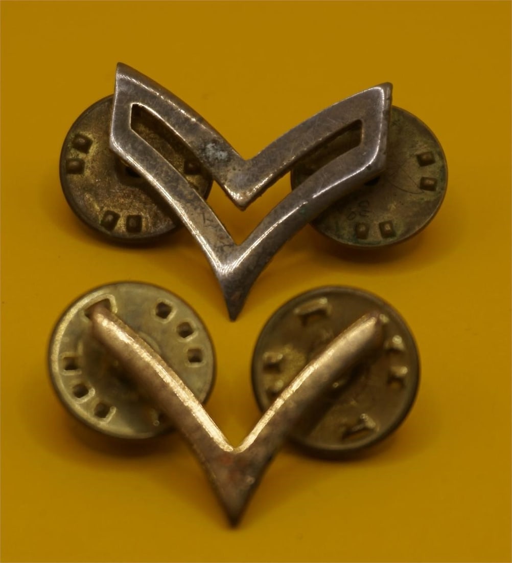 WWII Vintage Corporal Uniform Insignia Pins: These are vintage corporal uniform insignia pins. The V-shaped emblems are typically worn on the collar or uniform sleeves to signify the rank of corporal in various military or quasi-military organiz