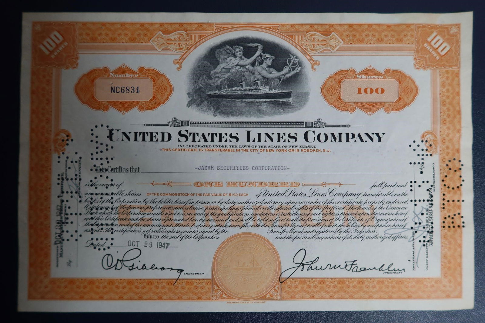 100-share US Lines Co. Stock Certificate: A collectible 100-share United States Lines Company stock certificate, issued on October 29, 1947. The certificate features an ornate border and a vignette of two allegorical figures protecting an oce