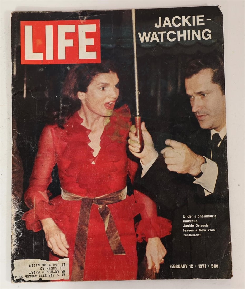 1971 LIFE Jackie Watching Issue: LIFE magazine issue dated February 12, 1971 featuring Jacqueline Kennedy Onassis on the cover titled "Jackie-Watching." The cover photograph shows Jackie Onassis leaving a New York restaurant under a