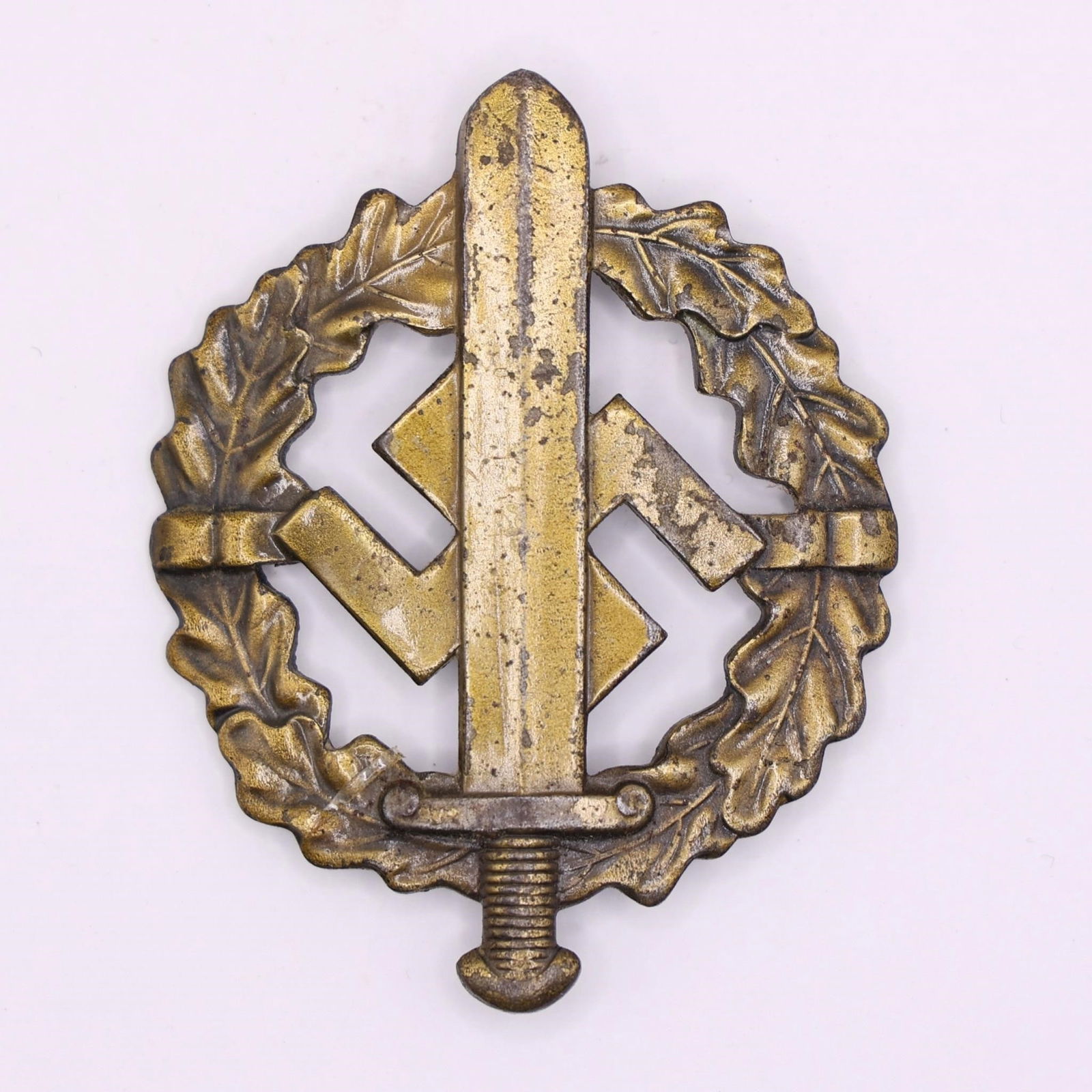 German SA Sports Badge in Bronze: WWII-era German NSDAP SA/SS Sports Badge (SA-Sportabzeichen) in bronze, die-struck magnetic metal with bronze wash, oak-leaf wreath and sword over swastika design. Reverse marked "Eigentum der
