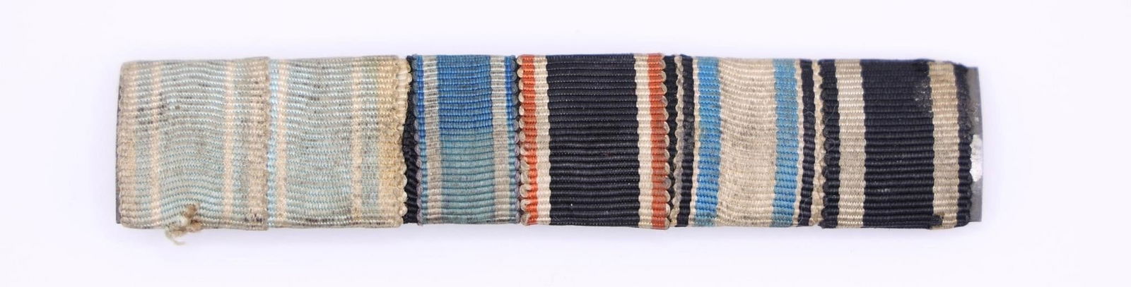 German Medal Ribbon Bar Grouping: Collection of seven historic German medal ribbons, featuring awards from both World War I and World War II. Includes a variety of service, campaign, and merit decorations. Metal core with horizontal