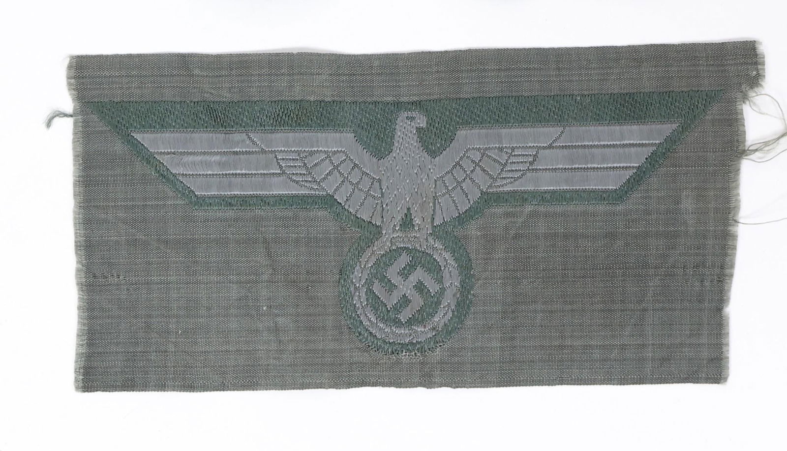 WWII German Heer M39 Woven Breast Eagle: This is a World War II German Army (Heer) M39 pattern machine-woven breast eagle patch. It is an insignia intended for wear on the combat field blouse. The eagle design is woven in pale grey rayon thr
