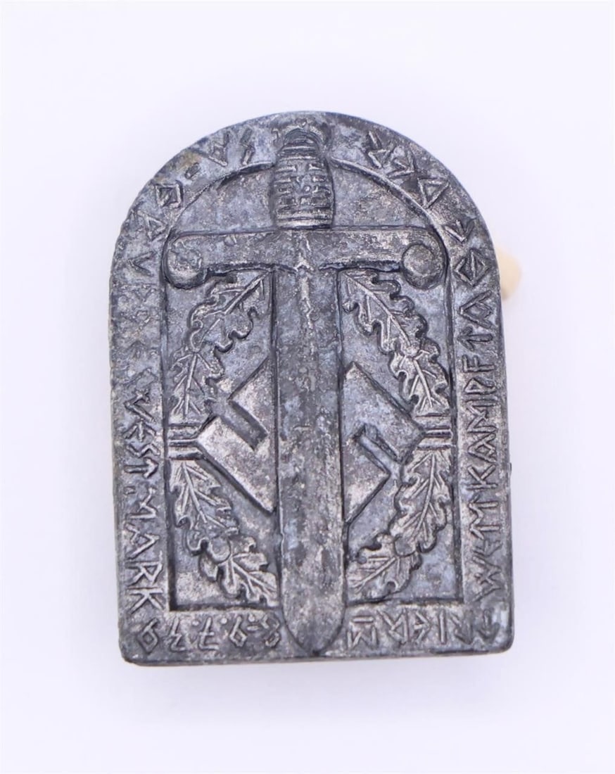 German WWII SA Sports Badge: Shield-shaped aluminum badge with dull grey finish, featuring the SA sports emblem of a vertical broadsword over a swastika within a laurel wreath, surrounded by the inscription "WETTKÄMPFE DER