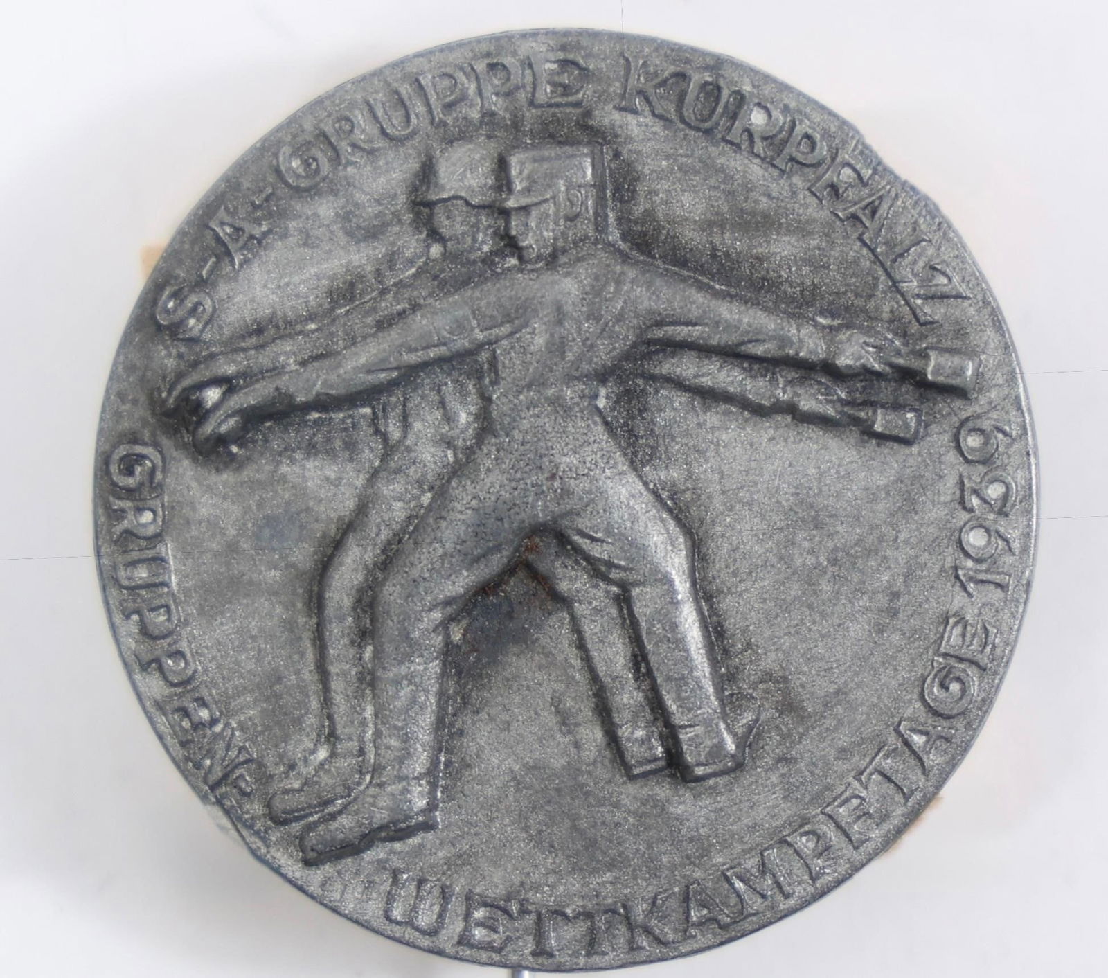 1939 SA Kurpfalz Sports Competition Tinnie Badge: This item is a 1939 commemorative badge for the SA (Sturmabteilung) sports competitions in the Kurpfalz region of Germany. It is often referred to as a "tinnie," a type of commemorative badge issued
