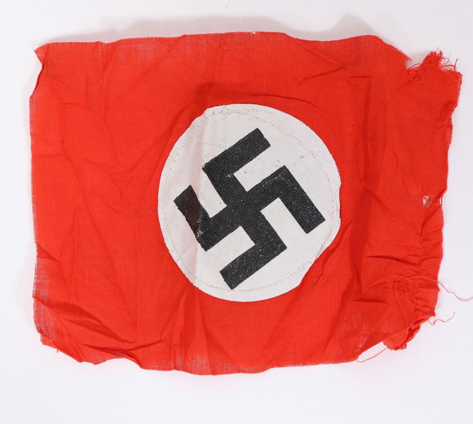 WWll German Party Armband: Two sided red cloth armband featuring a white circular roundel with a black angled swastika at the center. Constructed of woven fabric with finished edges. Measures approximately 7.5 × 6.7 inches.