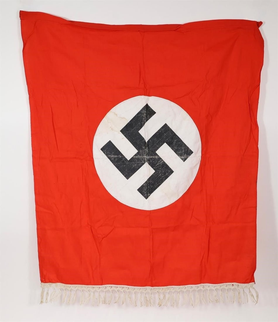 WWII German Party Banner Flag: World War II-era German red banner with central swastika emblem, showing wear from use with rope ties.