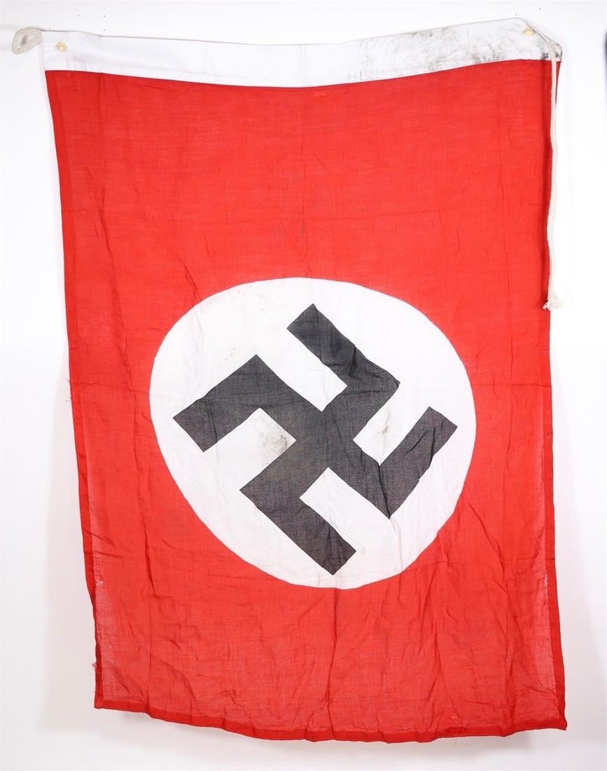 Third Reich-Era German Red Flag: Rectangular red cloth flag with a white circular roundel at the center, bearing a black angled swastika. Finished with a white fringe along the bottom edge. Measures approximately 37 × 30 inches.