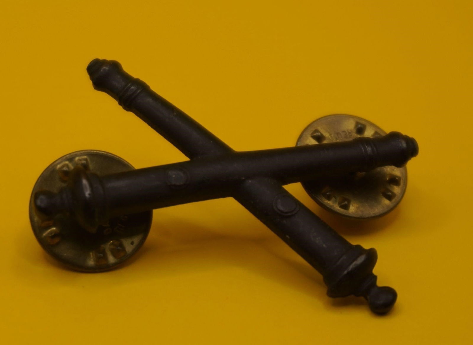 US Army Field Artillery Officer Collar Devices: This is a pair of US Army Field Artillery Officer subdued metal collar devices. The insignia, featuring crossed cannons (field guns), has been used on artillerists' uniforms for more than 180 years.