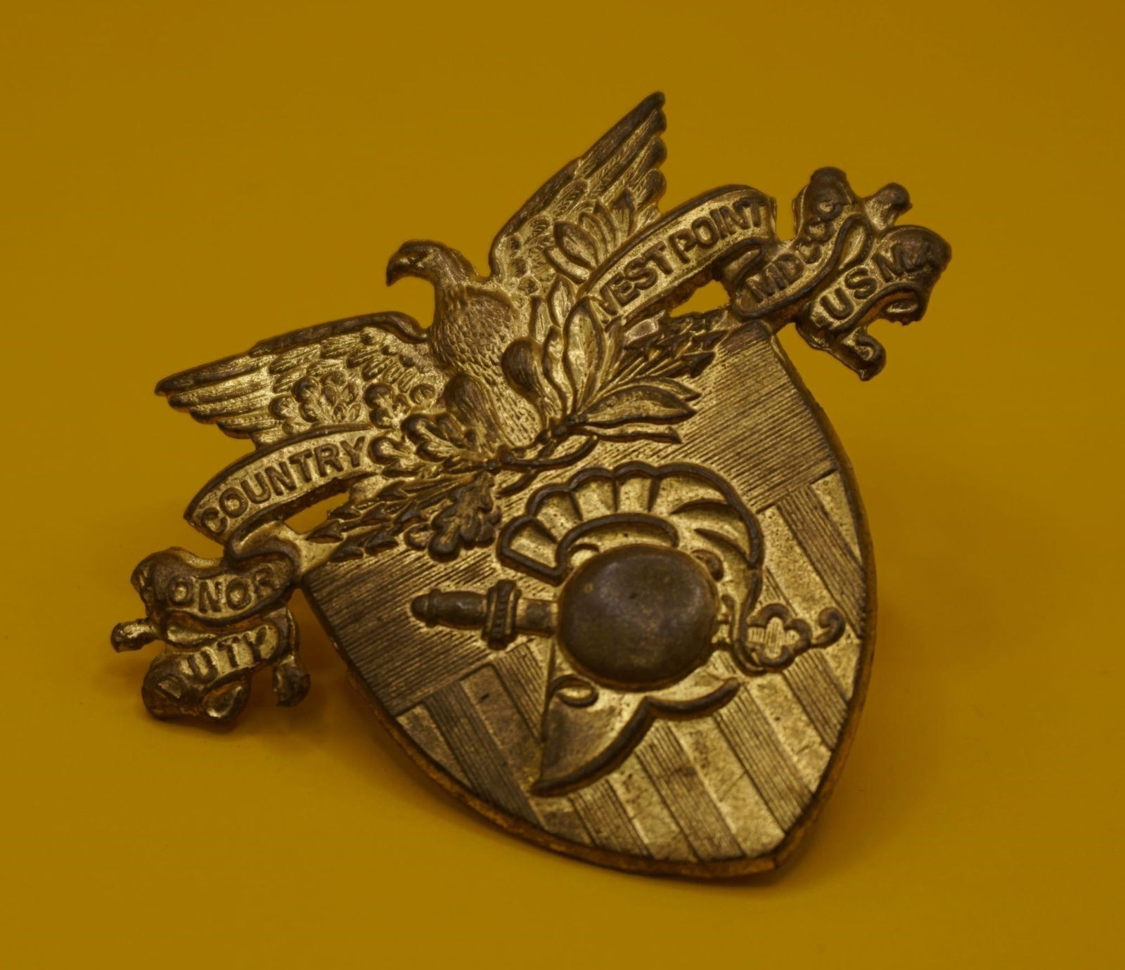 WWII Vintage US USMA at West Point Cap Insignia: The image displays a vintage US Military Academy (USMA) at West Point cap insignia. The insignia features the academy motto, "DUTY HONOR COUNTRY". It includes the letters "USMA" (United States Militar