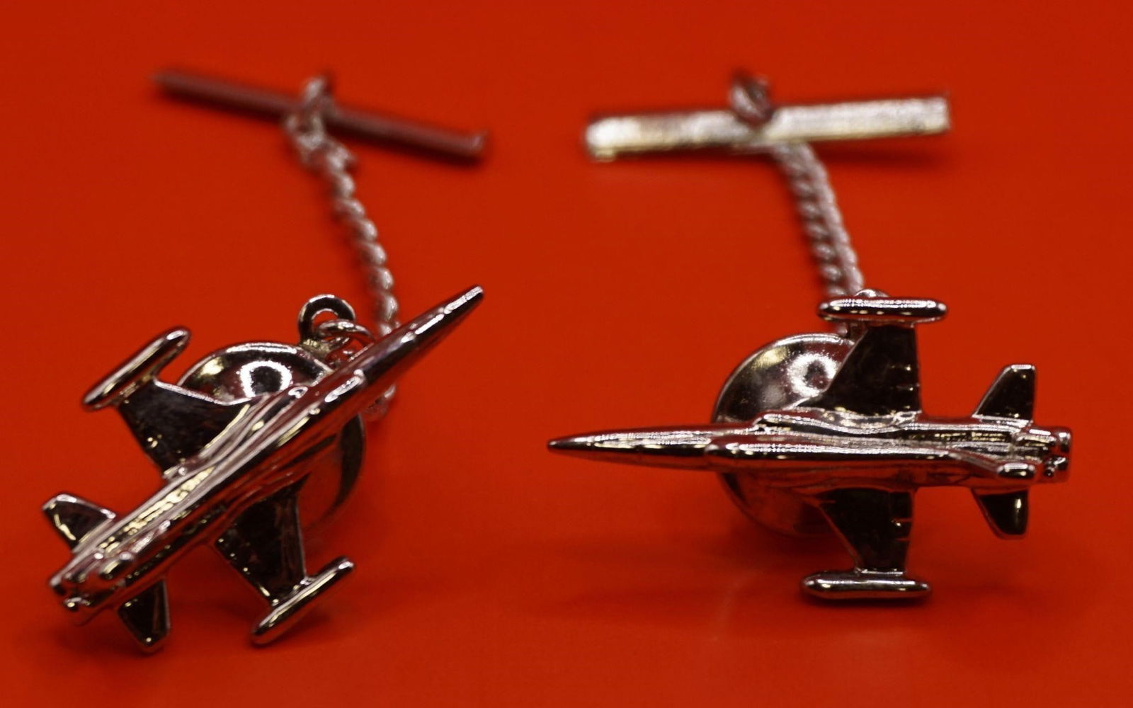 Silver Tone Airplane Tie Tacks Set: This is a set of silver-tone airplane tie tacks, with one depicting a jet fighter and the other potentially a Boeing 747 or space shuttle variant.
