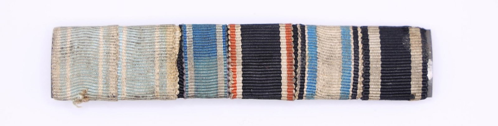 German Medal Ribbon Bar Grouping: Collection of seven historic German medal ribbons, featuring awards from both World War I and World War II. Includes a variety of service, campaign, and merit decorations. Metal core with horizontal p