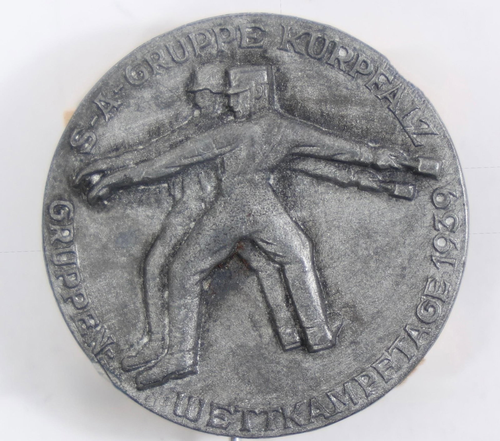 1939 SA Kurpfalz Sports Competition Tinnie Badge: This item is a 1939 commemorative badge for the SA (Sturmabteilung) sports competitions in the Kurpfalz region of Germany. It is often referred to as a "tinnie," a type of commemorative badge issued f