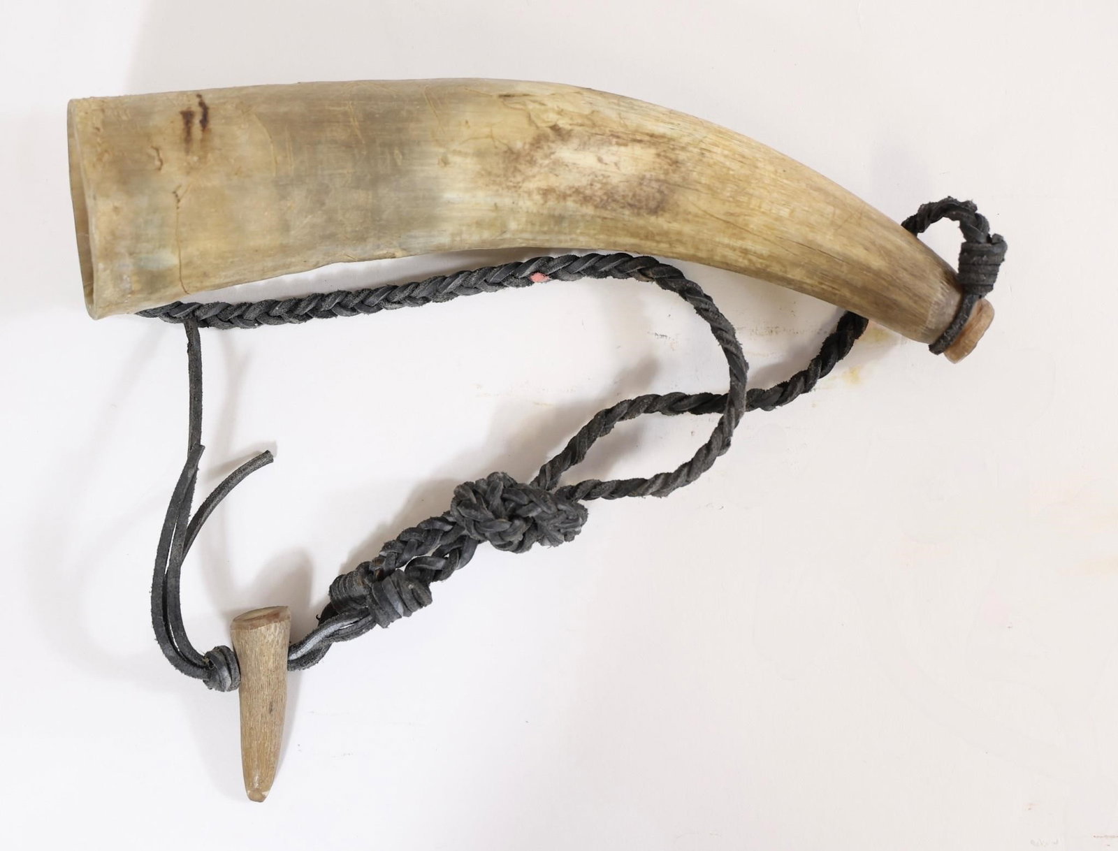 Vintage Powder Horn w/ Braided Strap: Natural horn powder flask with wooden plug and braided strap. Shows age, wear, and surface marks.