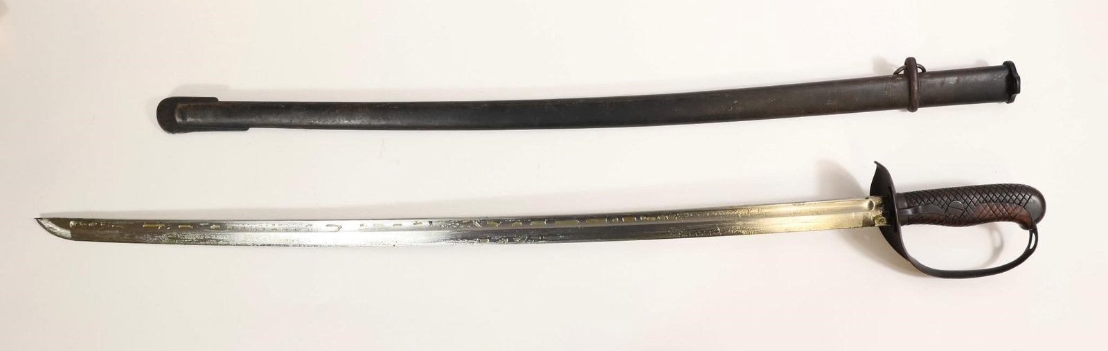 NCO Officer's Sword and Scabbard: 35 1/2" overall length with a 30" blade. Features a D-guard and steel scabbard, serial numbered. Blade remains in excellent condition with heavy cosmoline preservation