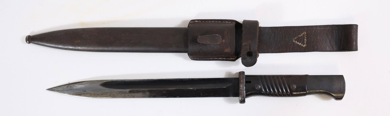 WWII German Military Bayonet w/ Scabbard & Frog: WWII-era German military bayonet with metal blade and grip, includes scabbard and leather frog. Shows wear and age-related patina.Approx. OL: 15"BL: 10"