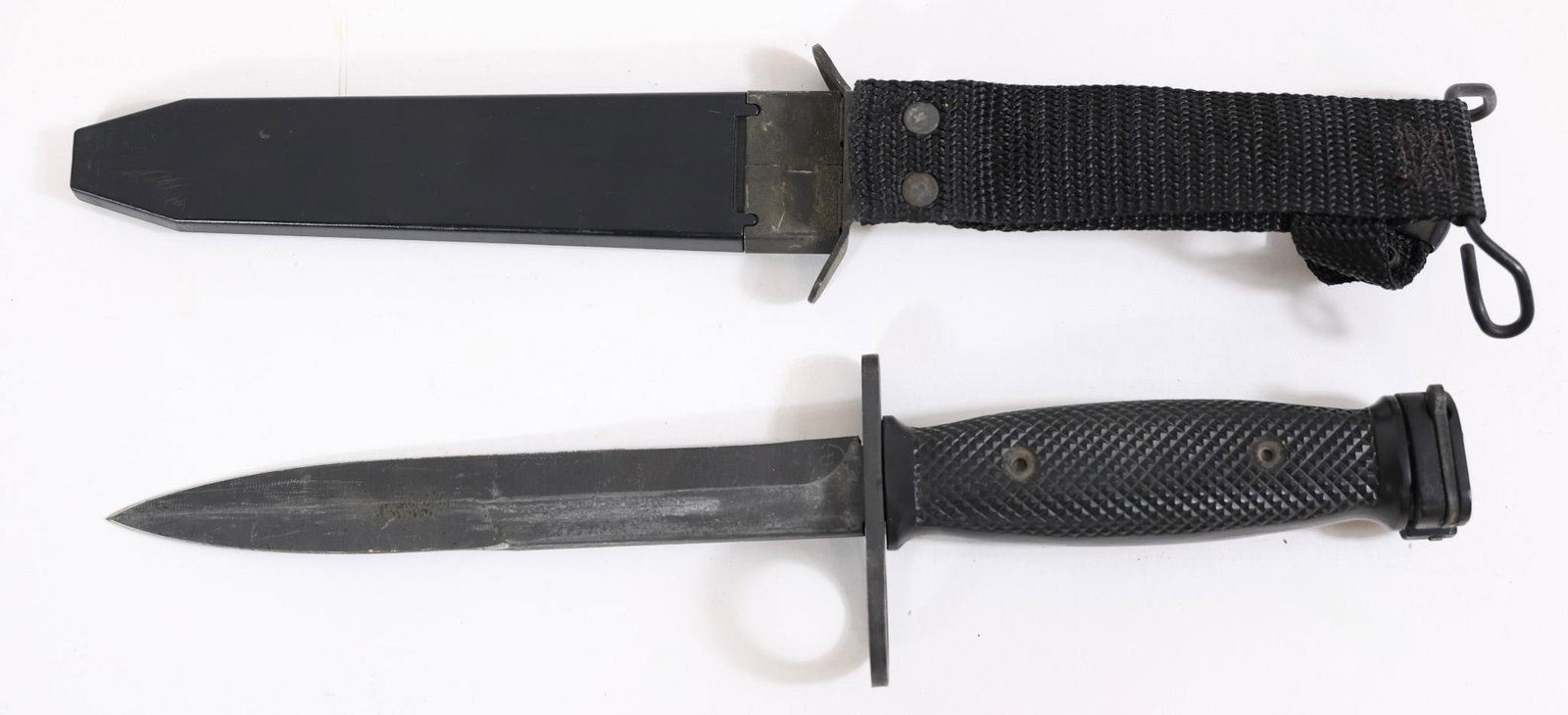 US M7 Military Bayonet w/ Scabbard: US M7 military bayonet with black grip and blade, includes scabbard. Shows light wear from use and handling.Approx. OL: 12"BL: 7"