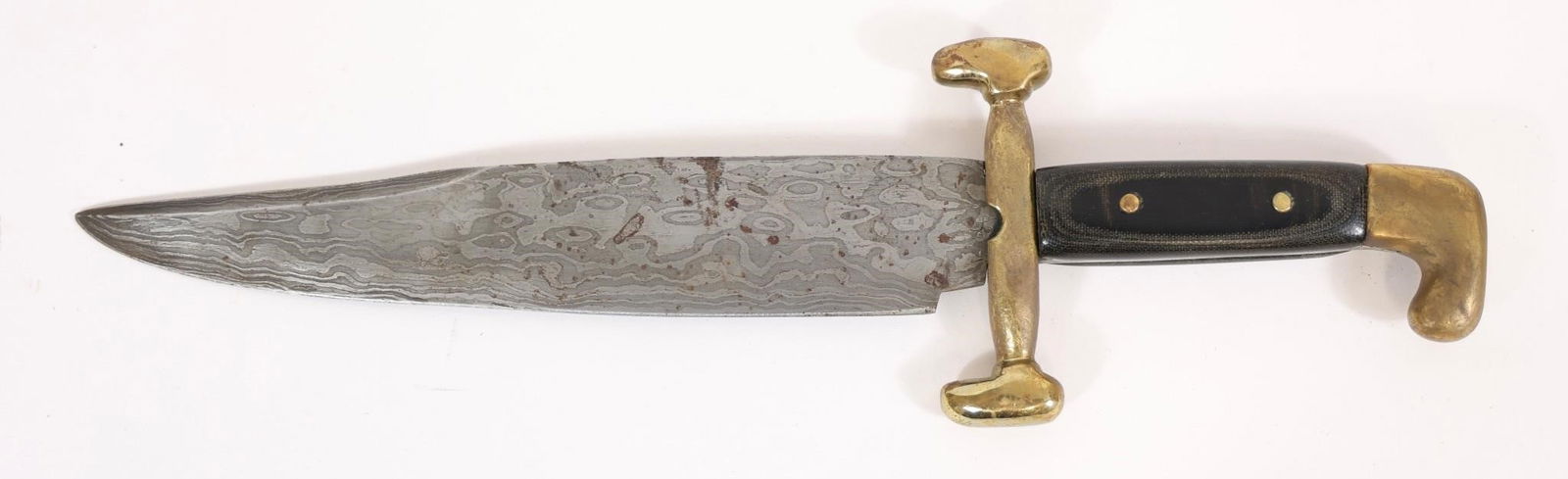 J.P. Jenkins 17 1/4" Damascus Bowie: 11 1/4" blade, J.P. Jenkins stamp at tang, cross stamp opposite tang, large brass guard and pommel. Features a patterned blade with visible wear and spotting, and a dark grip secured with brass pins.