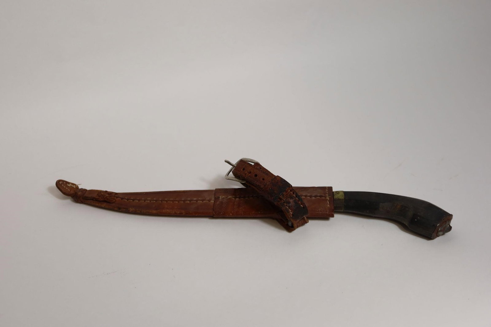 WWII Antique Bolo Knife and Sheath: The 11¾ inch (30 cm) single edge blade features a long clip point and an edge and blade bevel that begins just beyond a short, widened ricasso. A dirty, dark patina overlies transverse and